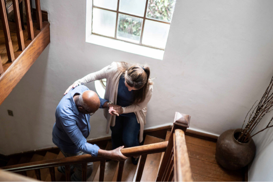 image of carer helping a resident up a flight of stairs
